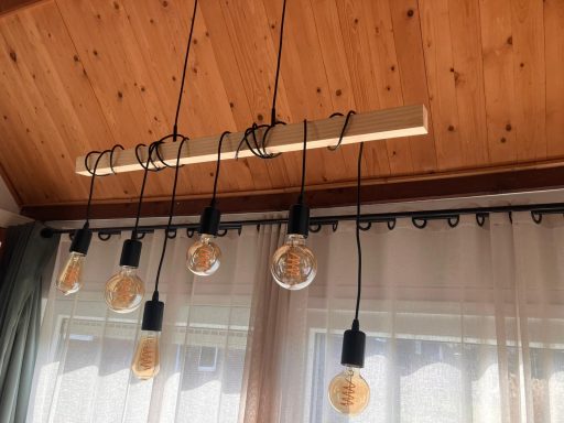 Eettafel lamp Moderne hanglamp met zes Edison-lampen aan een houten plafond.