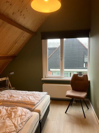 Slaapkamer Slaapkamer met twee bedden, een stoel en een venster met uitzicht op het buitenlicht.
